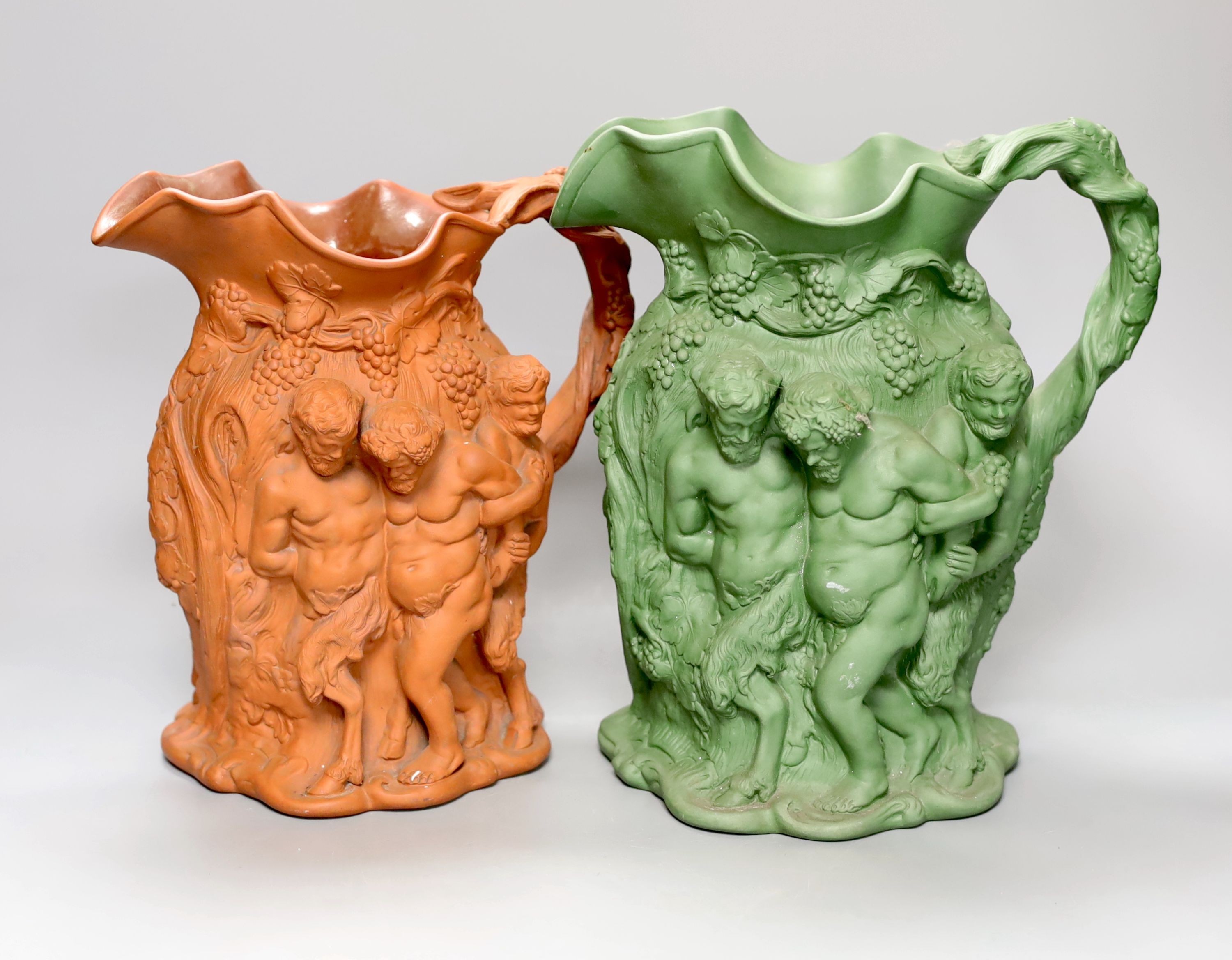 Two early 19th century terracotta Bacchanalian jugs, one green glazed 28cm